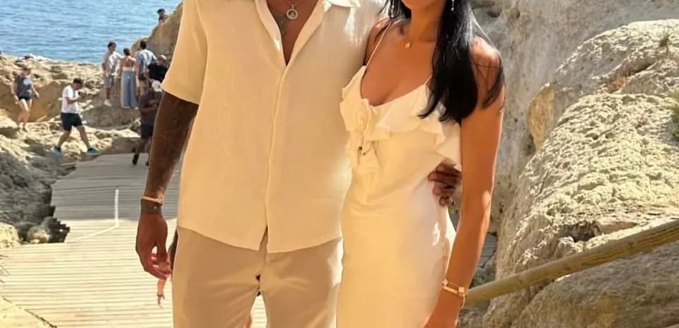 Pareja posando junto a la costa en un día soleado