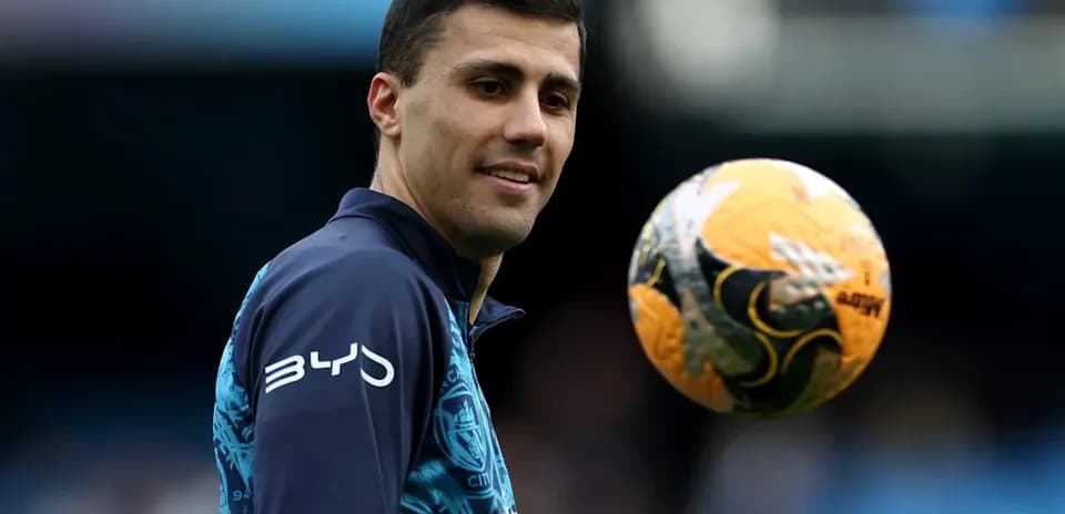 Jugador sosteniendo un balón de fútbol durante entrenamiento