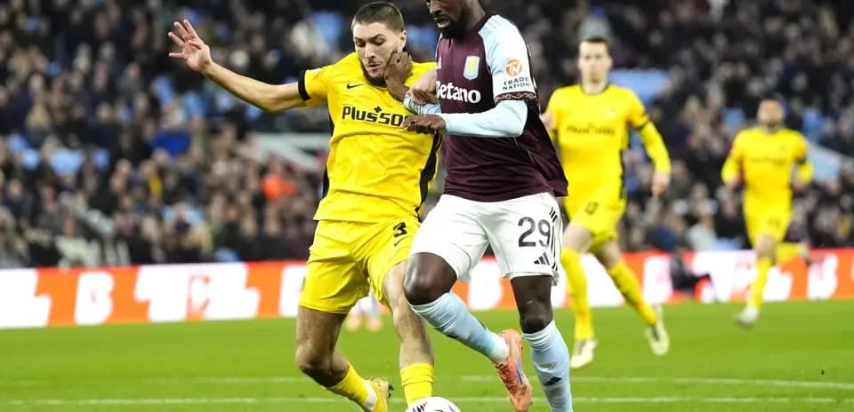 Jugador de Aston Villa driblando mientras es presionado