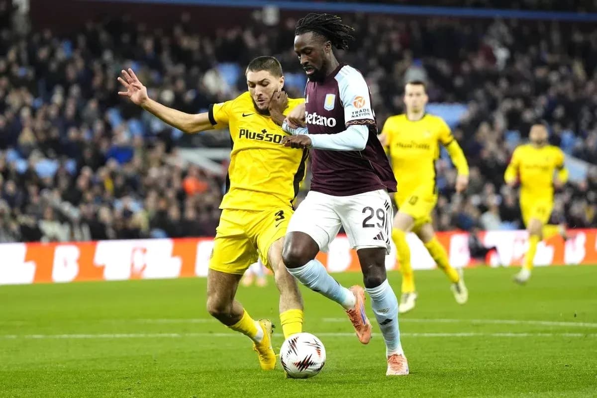 Jugador de Aston Villa driblando mientras es presionado