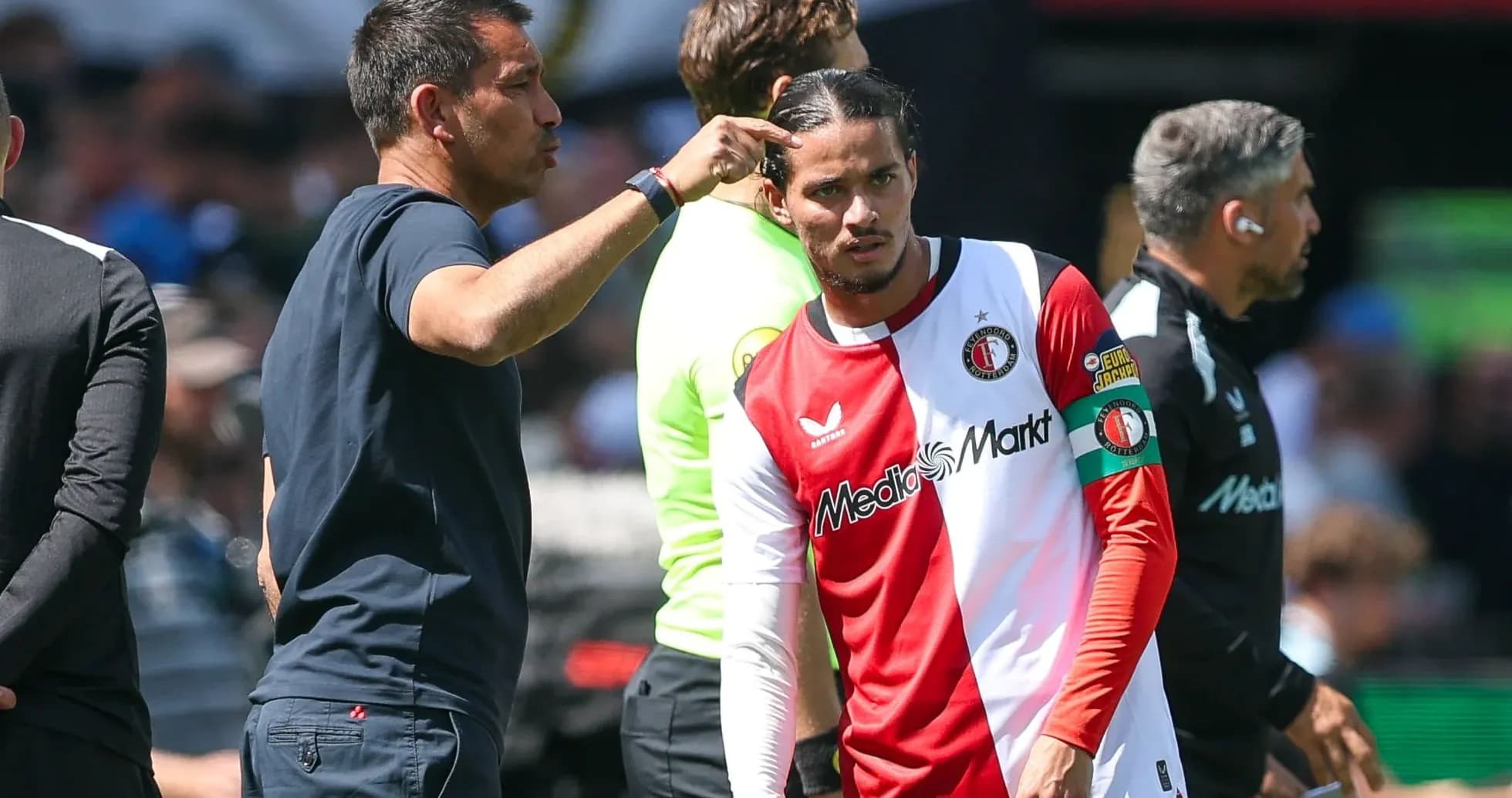 Entrenador dando instrucciones a jugador en banquillo