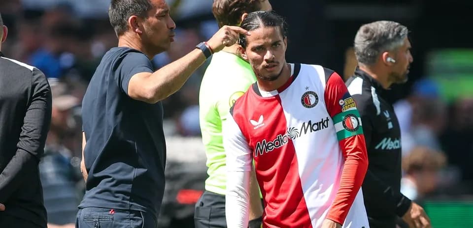 Entrenador dando instrucciones a jugador en banquillo