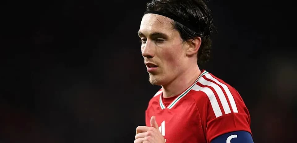 Jugador con banda de capitán en uniforme rojo