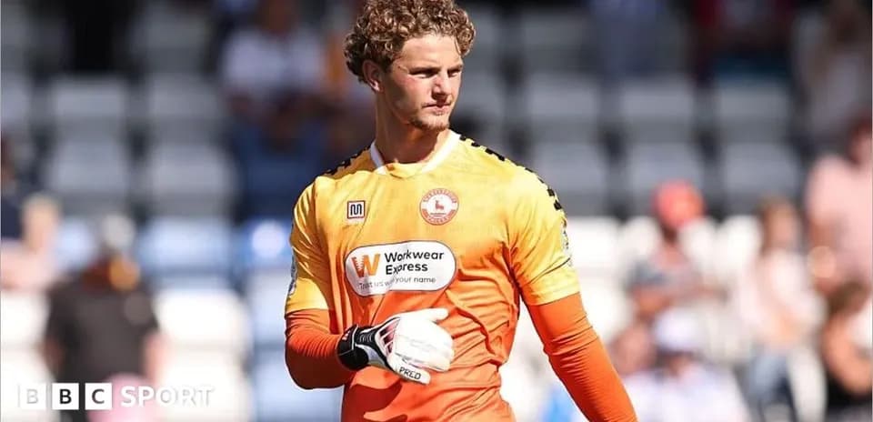 Portero con guantes en uniforme naranja en campo