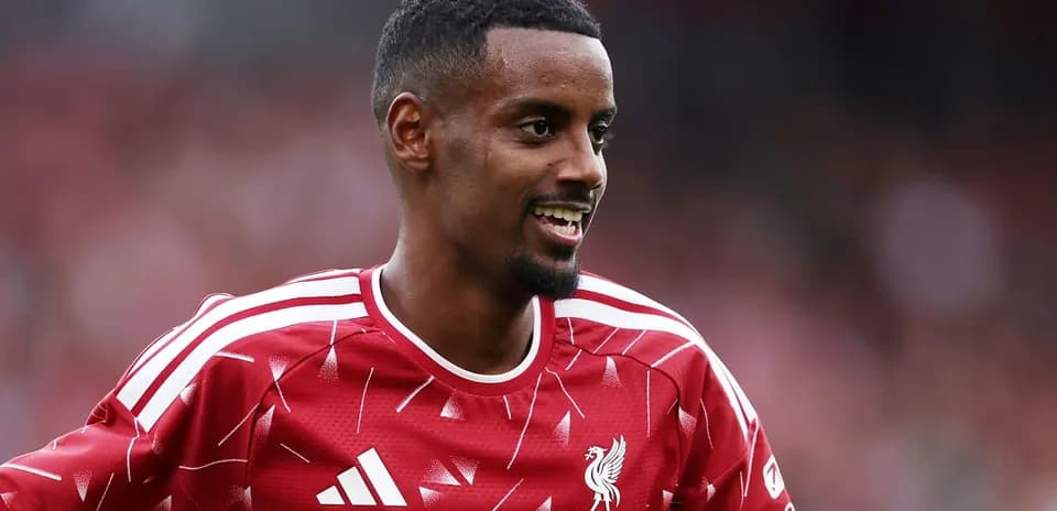 Jugador de Liverpool sonriendo en uniforme rojo