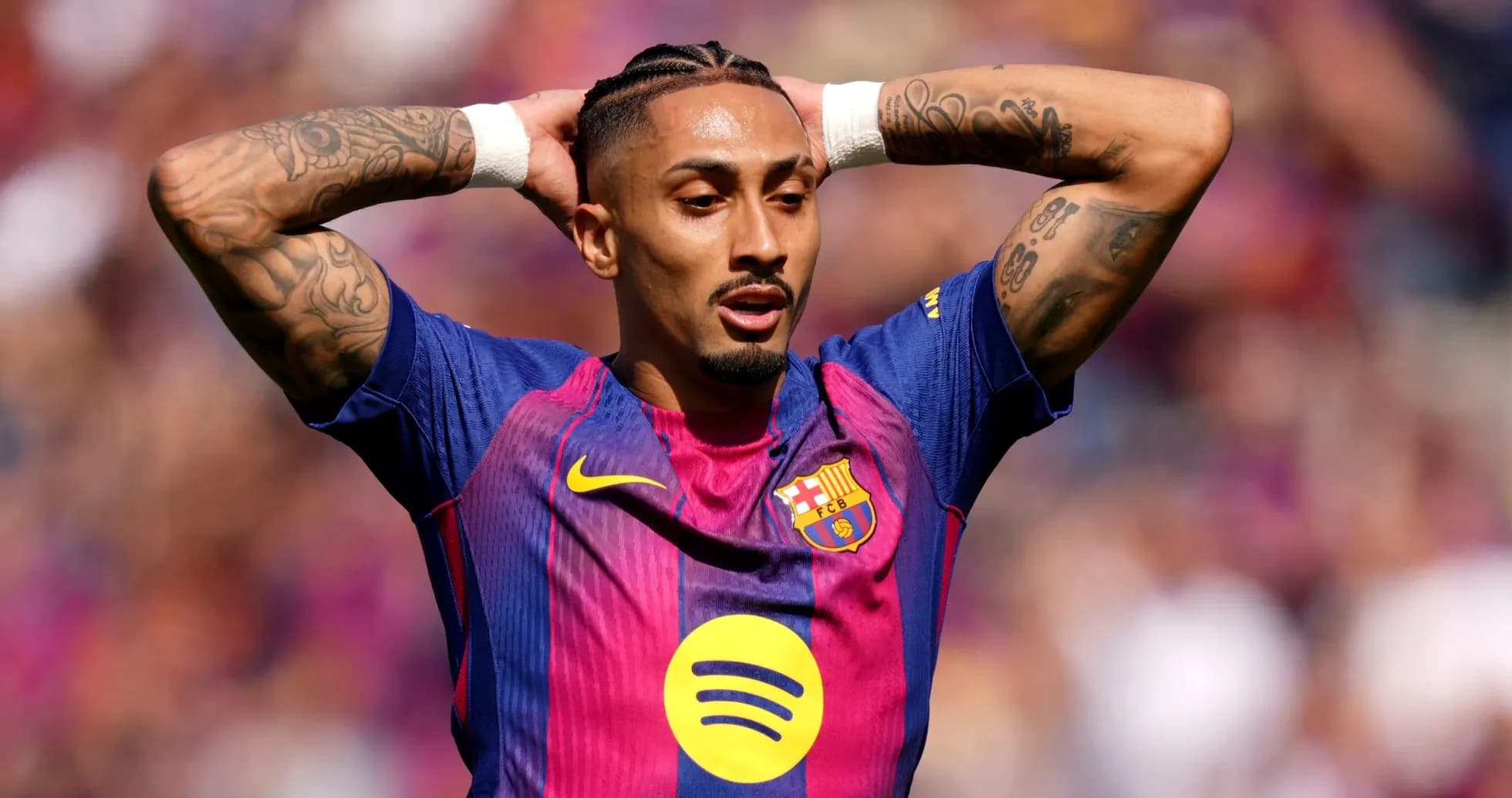 Jugador de Barça con brazos levantados en el campo