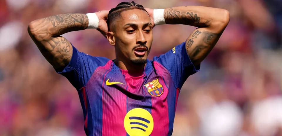 Jugador de Barça con brazos levantados en el campo