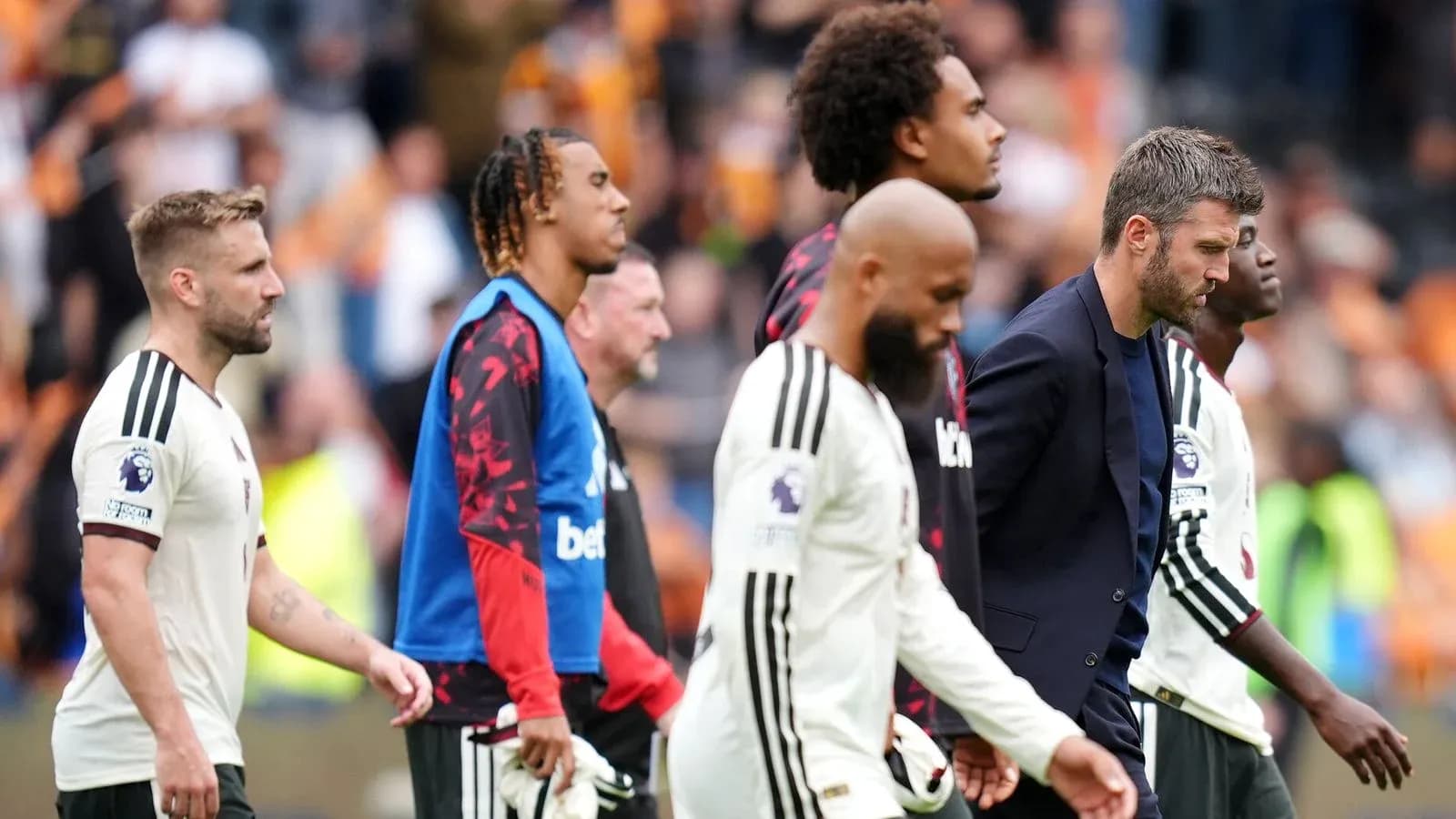 Jugadores y entrenador saliendo del campo tras el partido