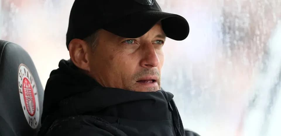 Entrenador sentado en el banquillo bajo la lluvia