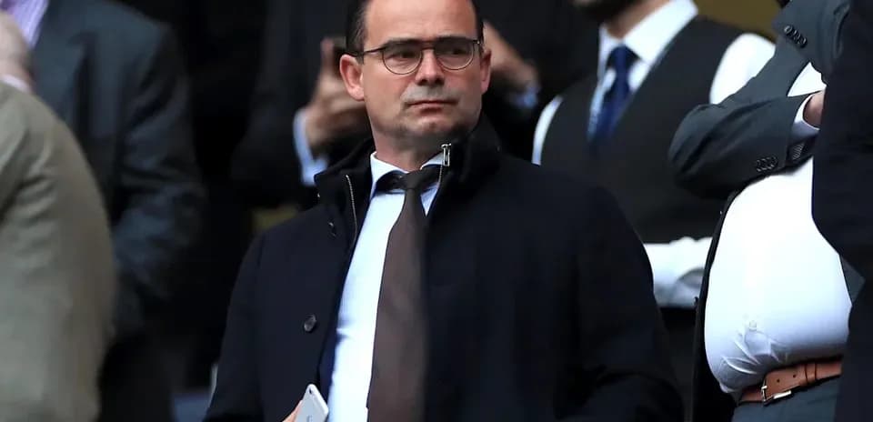 Hombre en traje observando un evento deportivo