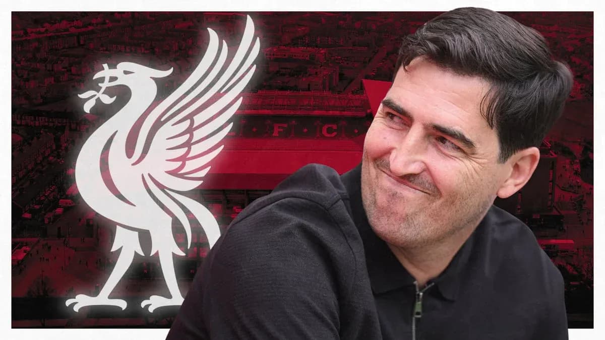 Entrenador sonriendo frente al logo de Liverpool