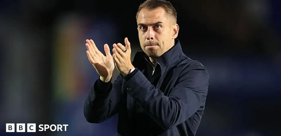 Entrenador aplaudiendo en el campo durante un partido