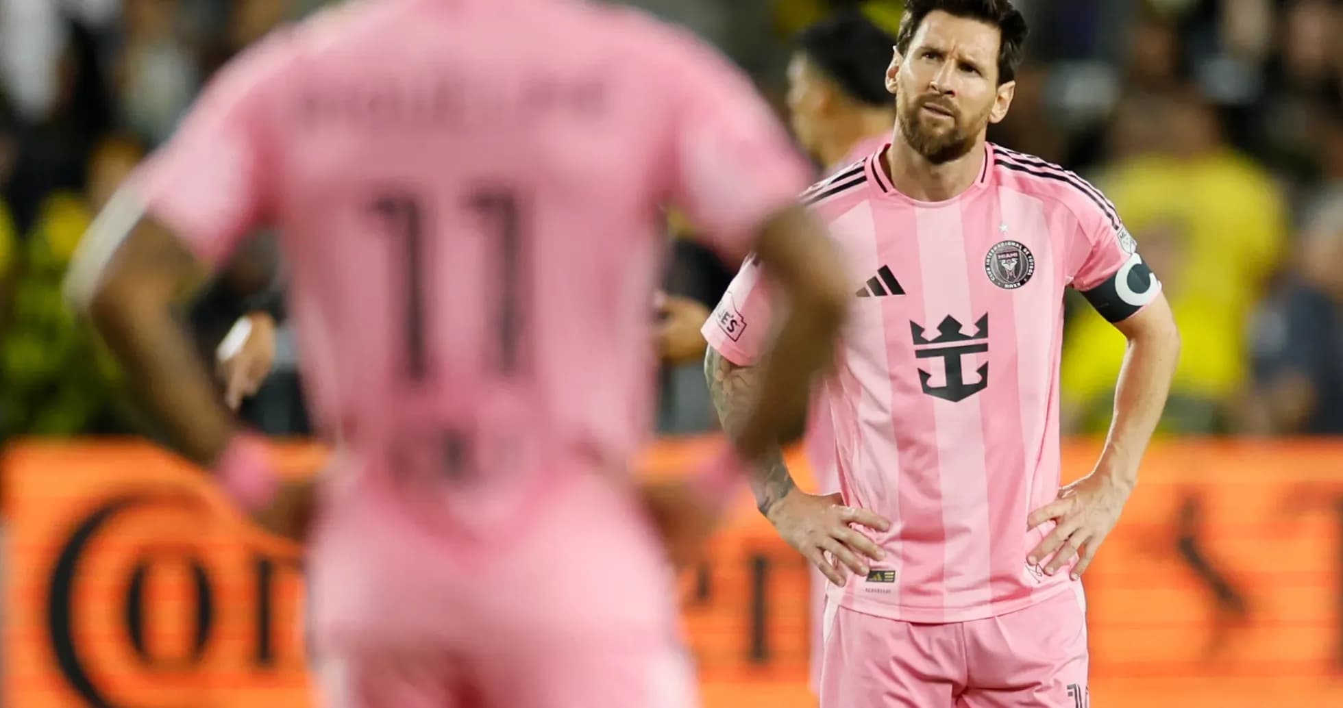 Lionel Messi y compañero en uniforme rosa durante partido