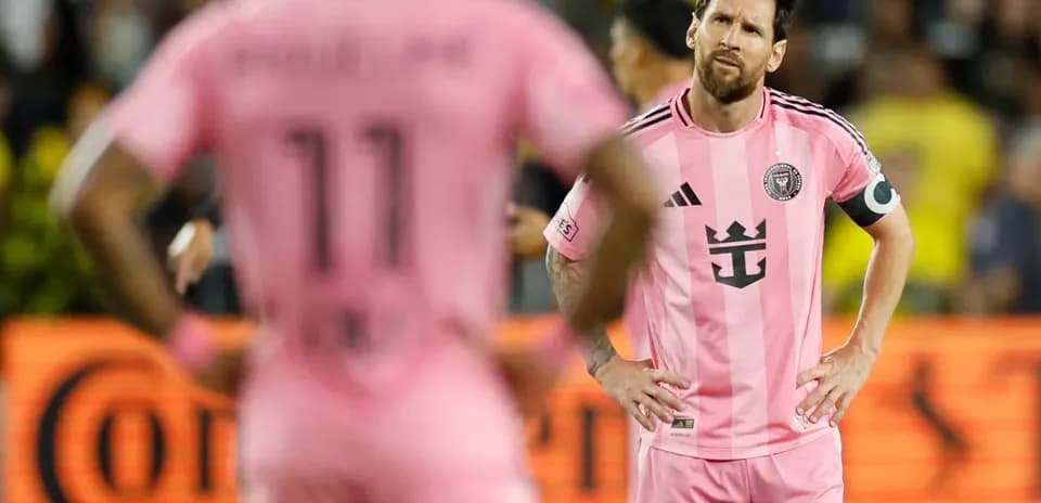 Lionel Messi y compañero en uniforme rosa durante partido