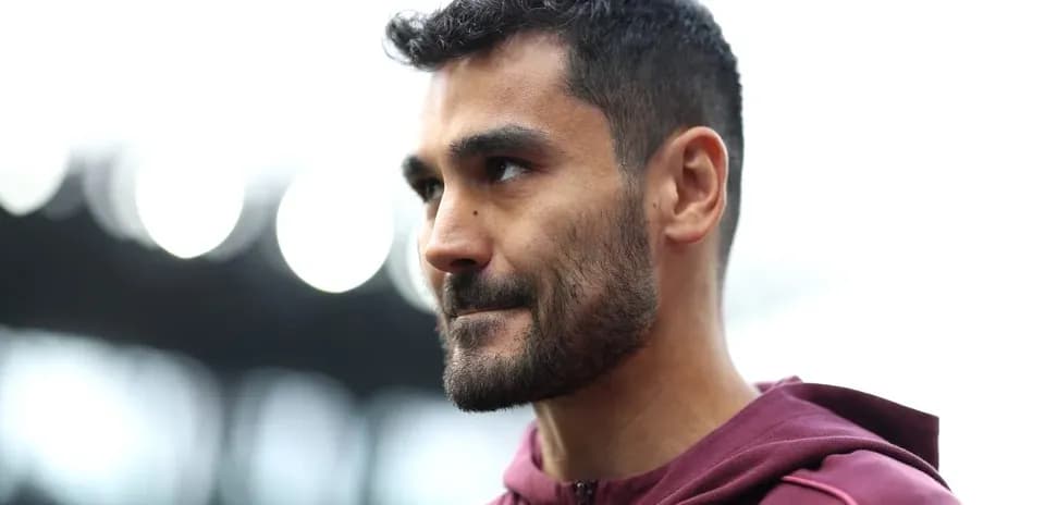 Jugador con chaqueta morada en estadio