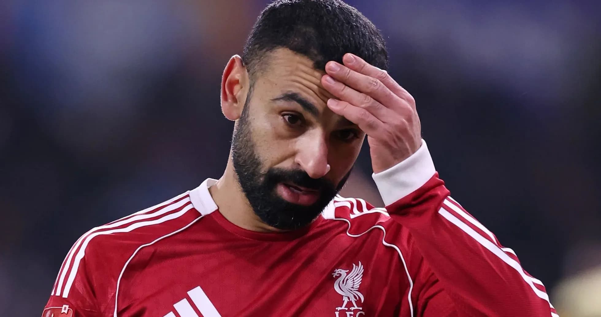 Jugador de Liverpool con camiseta roja tocándose la frente