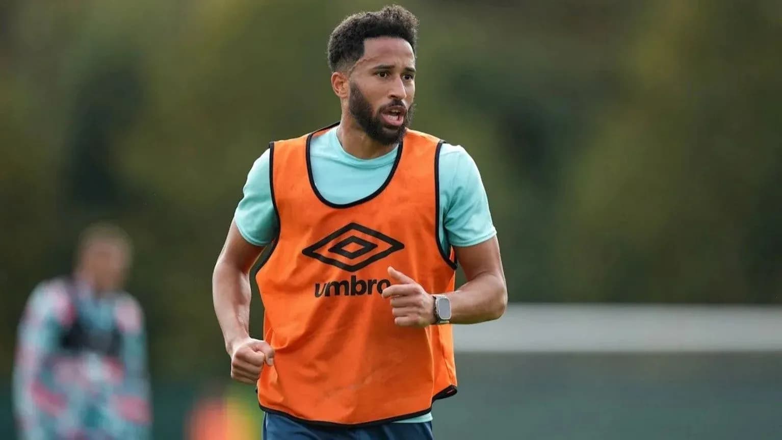 Jugador entrenando con chaleco naranja en campo