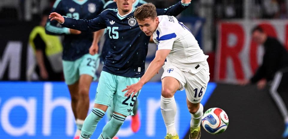 Jugador finlandés luchando por el balón contra alemán