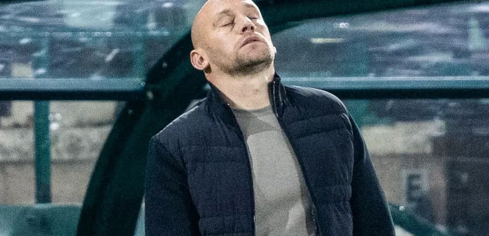 Entrenador en la banca con expresión seria