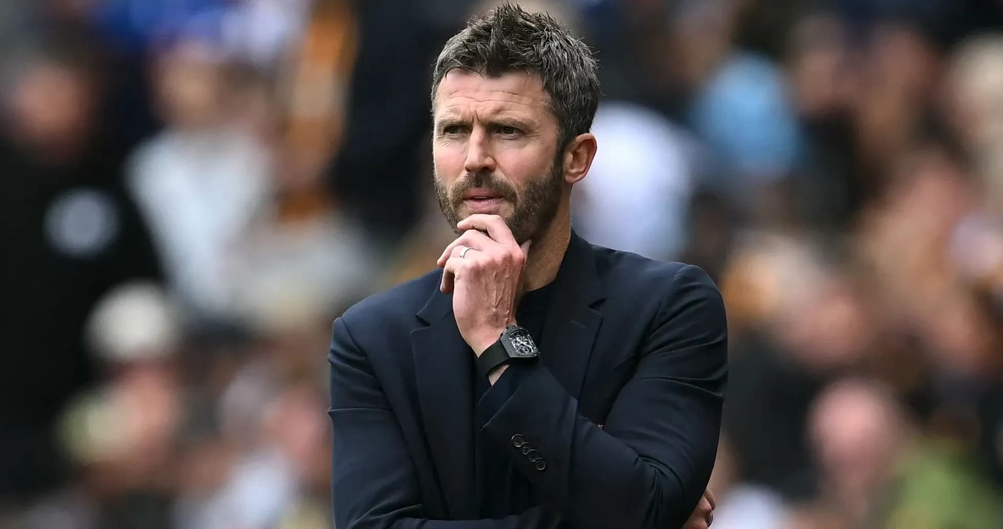 Entrenador observando el partido con expresión pensativa