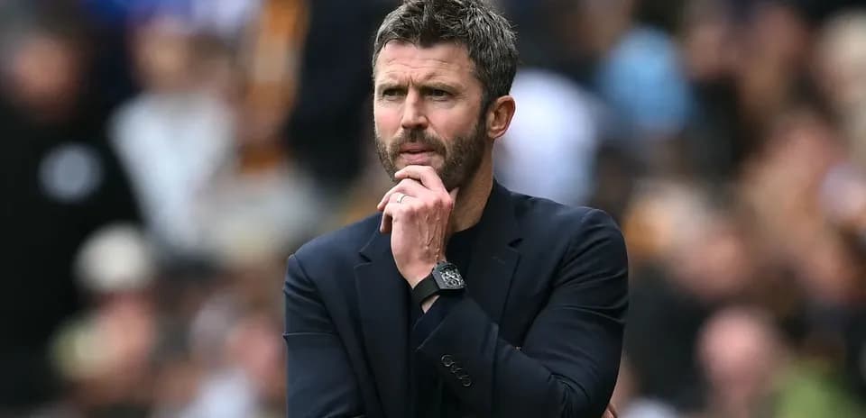 Entrenador observando el partido con expresión pensativa