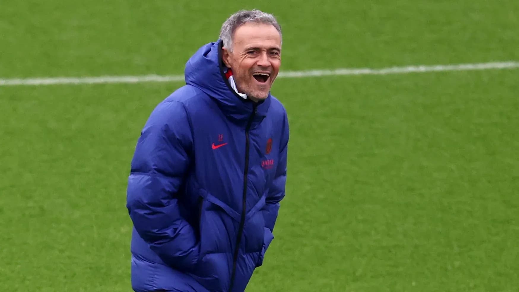Entrenador sonriendo en el campo de entrenamiento