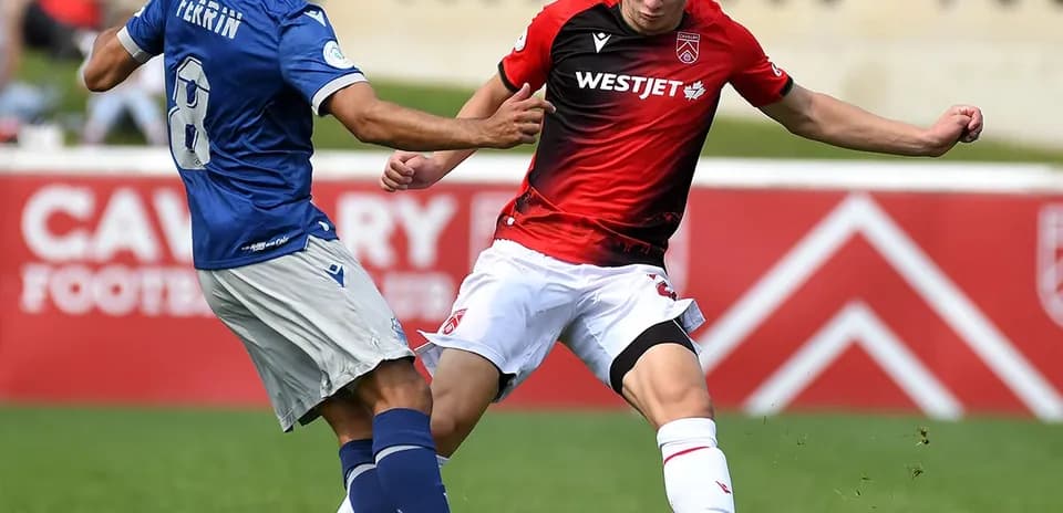 Jugador de Cavalry FC intenta quitar el balón