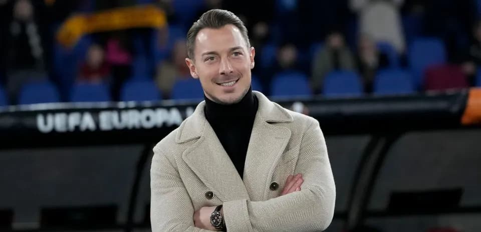Hombre sonriendo con abrigo en el estadio