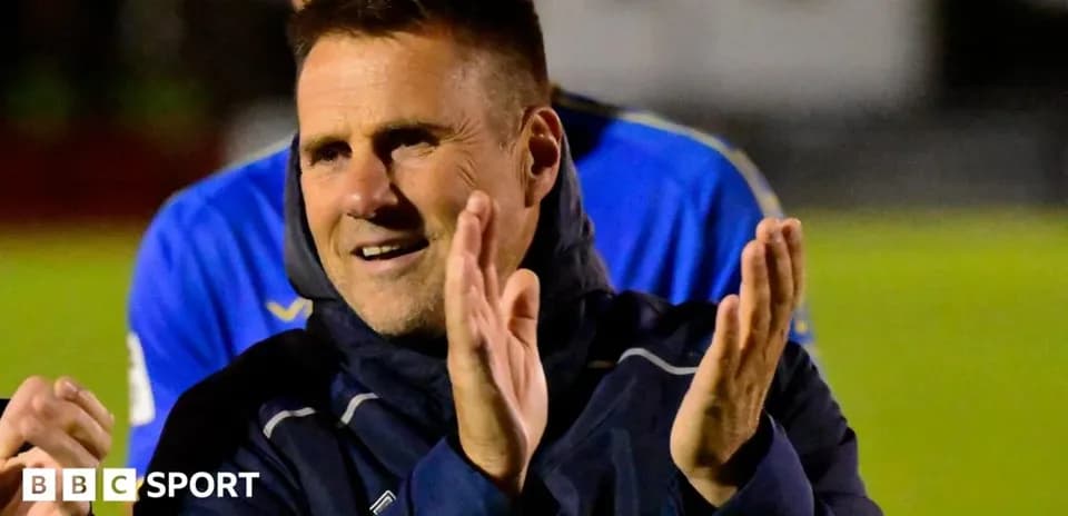 Entrenador aplaudiendo en el campo de fútbol