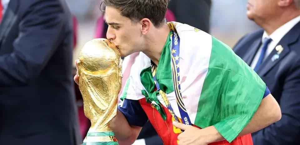 Jugador besando la Copa del Mundo con bandera