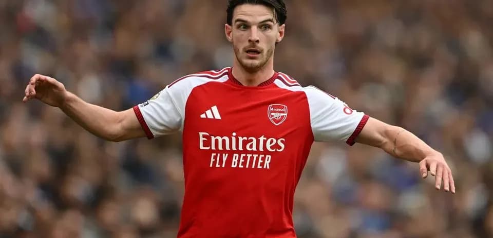 Jugador de Arsenal corriendo en el campo de fútbol