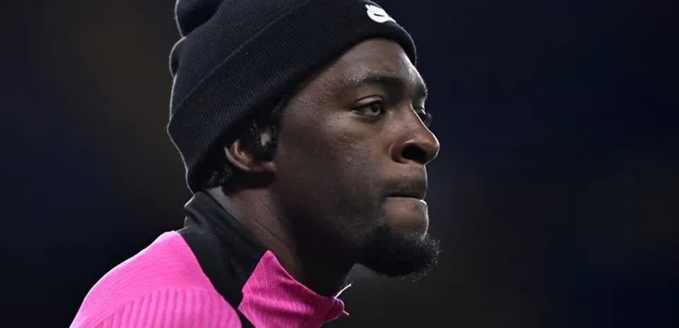 Jugador con gorro negro y camiseta rosa en perfil