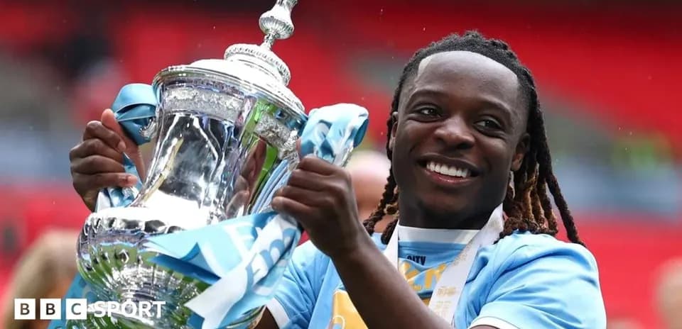 Jugador sosteniendo trofeo de la FA Cup sonriente