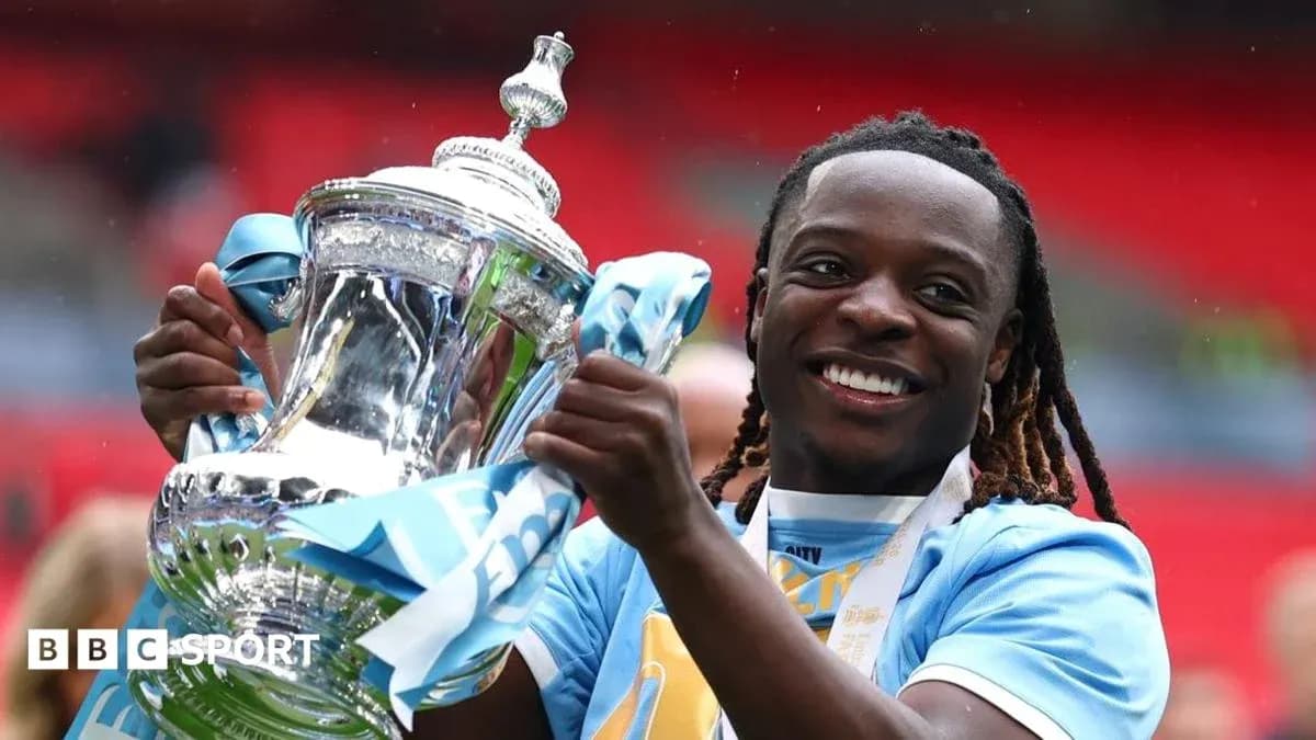 Jugador sosteniendo trofeo de la FA Cup sonriente