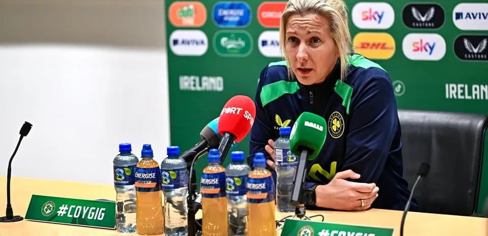 Entrenadora en conferencia de prensa con micrófonos