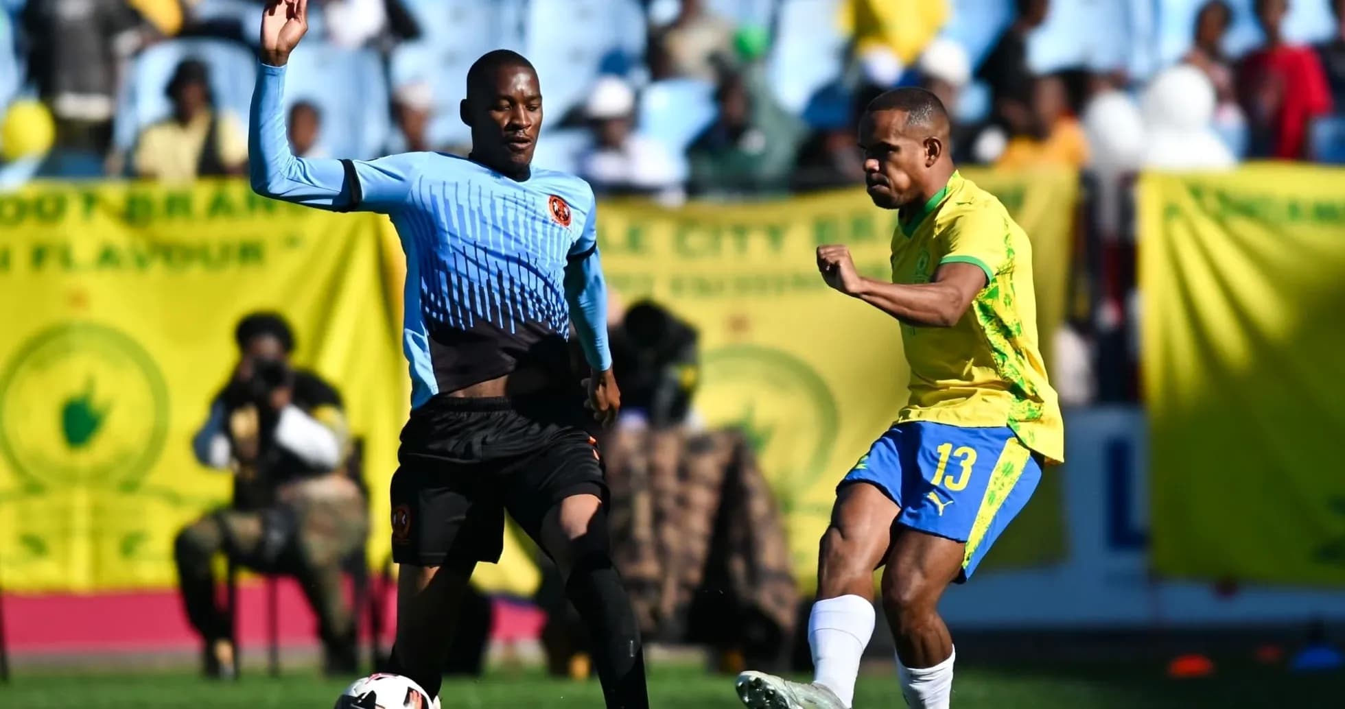 Jugador de amarillo intentando pasar a oponente en partido