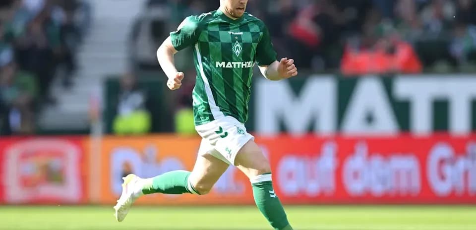 Jugador corriendo tras el balón en el campo