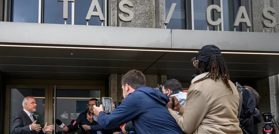 Persona hablando ante los medios frente al TAS