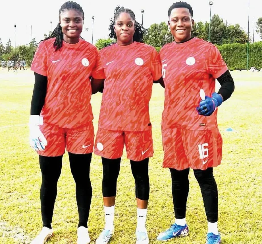 Tres jugadoras de fútbol posando en uniforme rojo