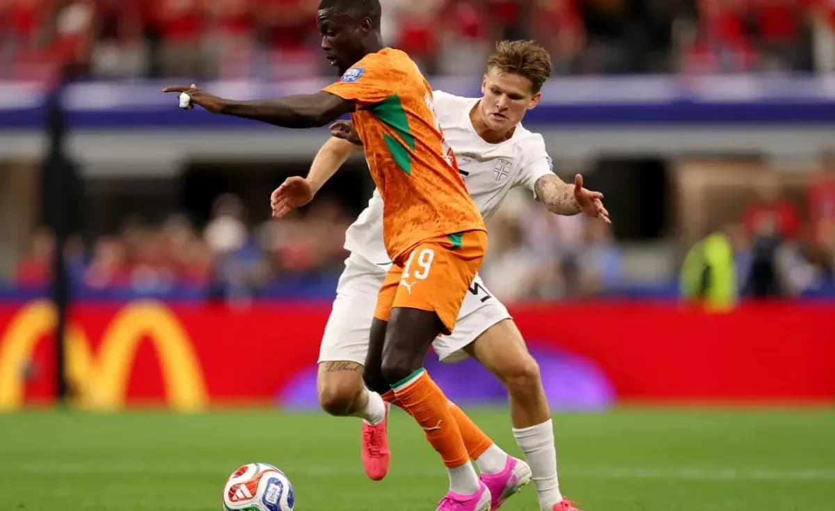 Jugador con camiseta naranja driblando a oponente en blanco