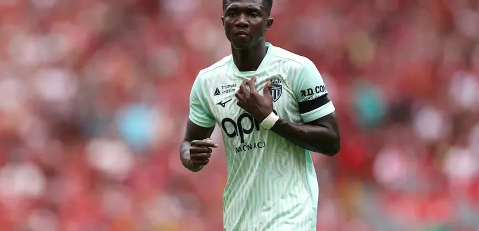 Jugador de Mónaco en partido, señalando su camiseta
