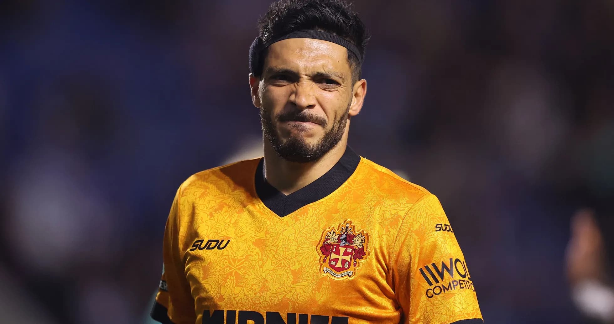 Jugador con camiseta naranja en el campo de fútbol