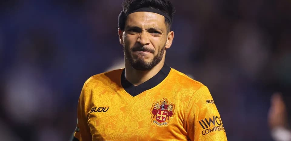 Jugador con camiseta naranja en el campo de fútbol