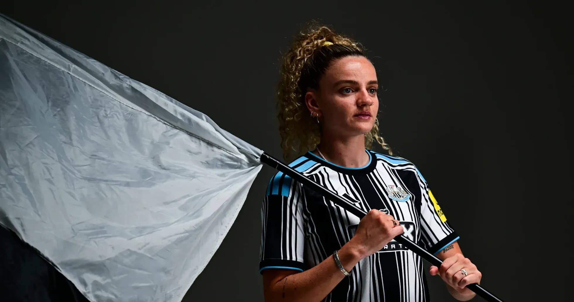 Jugadora sosteniendo una bandera en el estudio