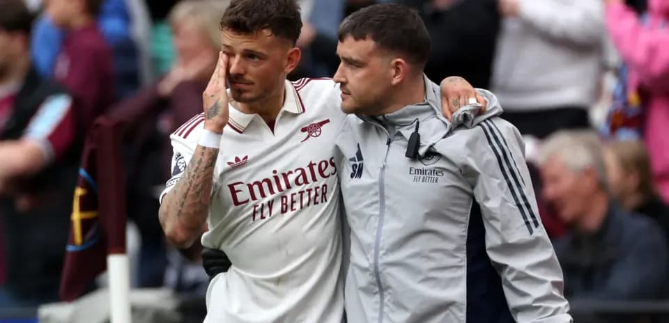 Jugador de Arsenal siendo ayudado por un miembro del equipo