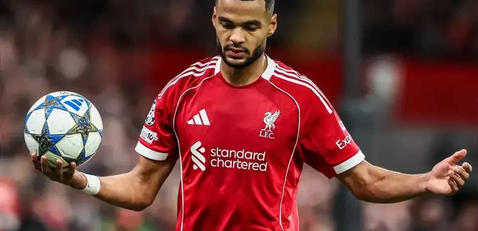Jugador de Liverpool sosteniendo un balón en el campo