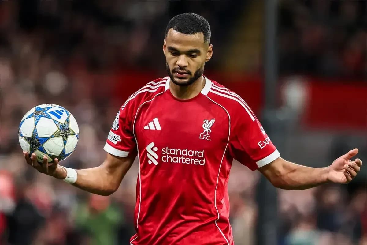 Jugador de Liverpool sosteniendo un balón en el campo