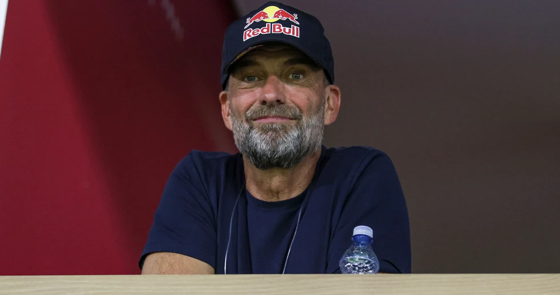 Hombre con gorra de Red Bull observando desde un palco