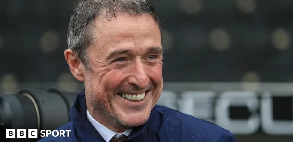 Entrenador sonriendo durante una rueda de prensa