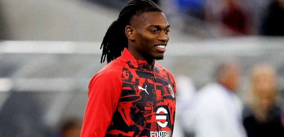 Jugador con sudadera roja sonriendo en el campo
